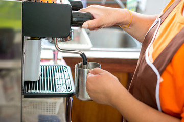 Steaming water for hot cappuccino with coffee machine