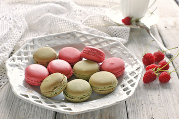 Macaroons with raspberries on vintage plate