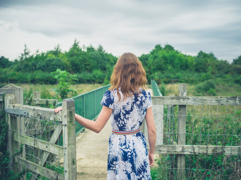 Young Woman Opening Gate In The Country