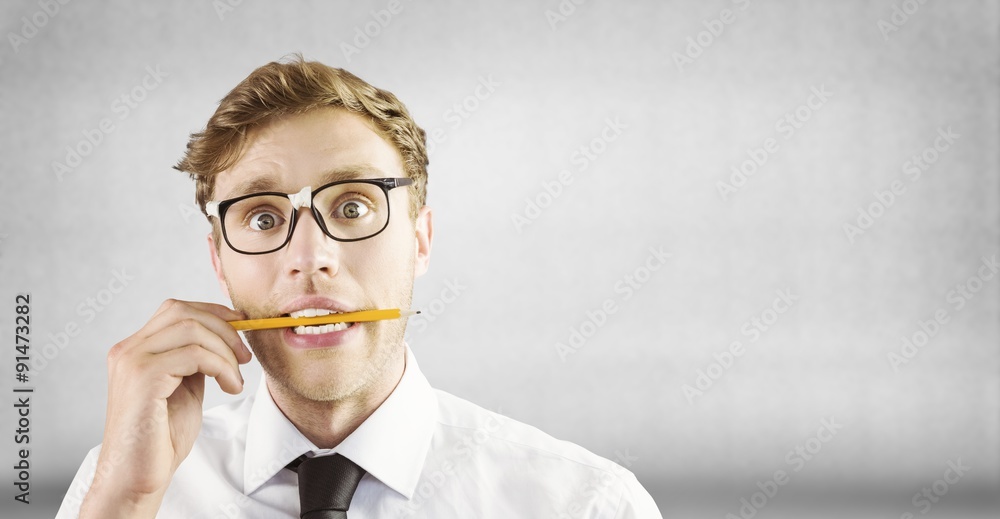 Poster Composite image of geeky businessman biting a pencil