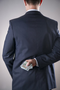 Businessman with money in studio. Corruption concept. Hundred dollar bills