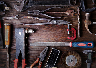 grungy old tools on a wooden background
