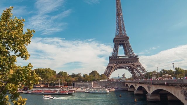Eiffel Tower by The Seine River 2, Day, Paris : A tilt shot of the Eiffel Tower on the Bridge &ldquo;Pont d&rsquo;I&eacute;na&rdquo; by a sunny summer day. Flyboats are passing by on the river Seine.