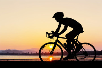Man fietsen op het strand twilight time