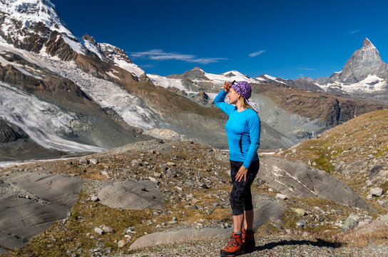 Woman hiker looking at glacier. Swiss