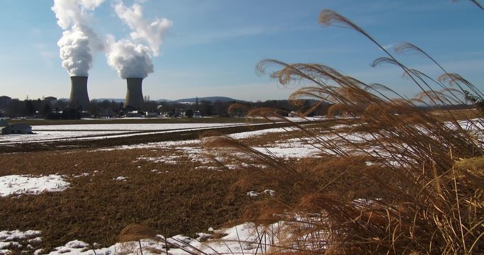 Smoke rises from the nuclear power plant at Three Mile Island, Pennsylvania with farm fields foreground.