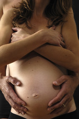 Fototapeta premium couple caressing pregnant belly,black background