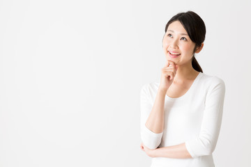 portrait of attractive asian woman thinking on white background