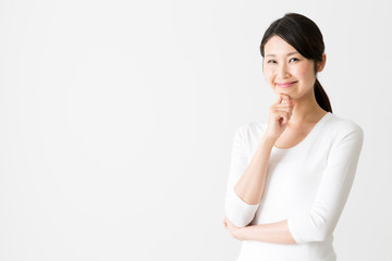 portrait of attractive asian woman thinking on white background