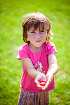 Cute girl eats fresh raspberries