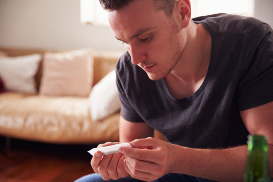 Young Man Smoking Marijuana At Home