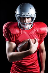 Portrait of confident sportsman holding American football