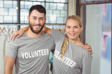 Portrait of colleagues with arms around standing 