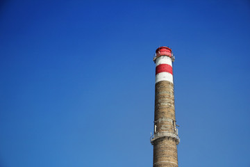 The brick chimney against the blue sky