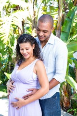 Smiling husband touching pregnant wife belly