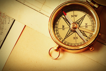 Antique brass compass over old map