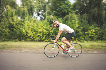 Young hipster man driving fast bicycle