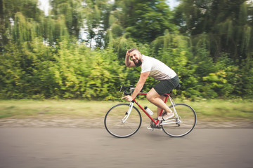 Obraz premium Young hipster man driving fast bicycle