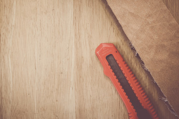 packaging cardboard sections and cutter on a wood surface