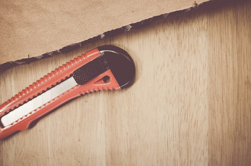 packaging cardboard sections and cutter on a wood surface
