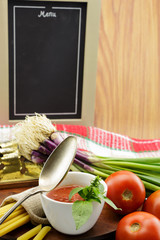 Tomato sauce with herbs and blackboard, with copy-space