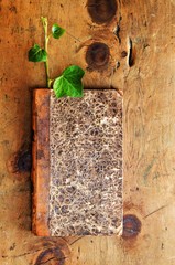 Old wood table with book and plant sprout in rustic vintage style. Top view. Retro concept background. For poster and design element.