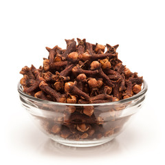 Front view of Organic black clove (Syzygium aromaticum) in glass bowl isolated on white background.