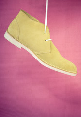 Green male shoes on pink background