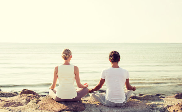 couple making yoga exercises outdoors
