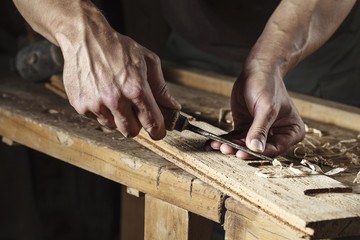 carpenter hands working with a chisel and carving tools - 91490608