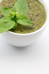 Pesto sauce and basil leaves, isolated on white background