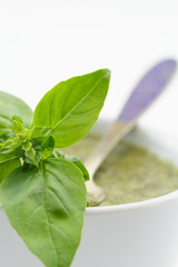 Pesto sauce and basil leaves, isolated on white background