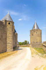 Fototapeta na wymiar Carcassonne, France. The road to the site of the former moat between the two rows of walls. Fortress of Carcassonne is included in the UNESCO World Heritage List