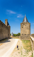 Fototapeta na wymiar Carcassonne, France. The road to the site of the moat between the inner (left) and external (right) ring of fortifications. Fortress of Carcassonne is included in the UNESCO World Heritage List
