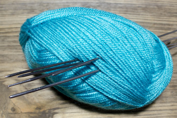 Skein fluffy blue yarn, metal spokes with  on wooden table