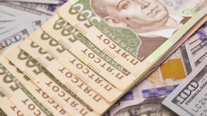 five hundred uah bills of Ukraine on the background of hundred-dollar bills
