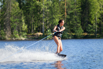 Young woman study riding wakeboarding on a lake