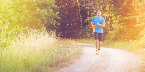Fototapeta premium Young Man jogging through the forrest
