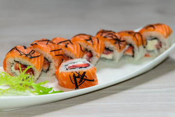 Close-up of a white plate with sushi set -  salmon with strawber