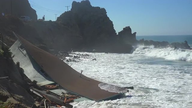 A house along the Malibu coastline collapses into the sea after a major storm surge.