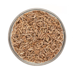 Top view of Organic Cumin seed (Cuminum cyminum) in glass bowl isolated on white background.
