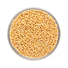 Top view of Organic yellow mustard (Brassica alba) in glass bowl isolated on white background.