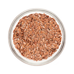 Top view of Organic Linseed or Flaxseed (Linum usitatissimum) half filled in glass bowl isolated on white background.
