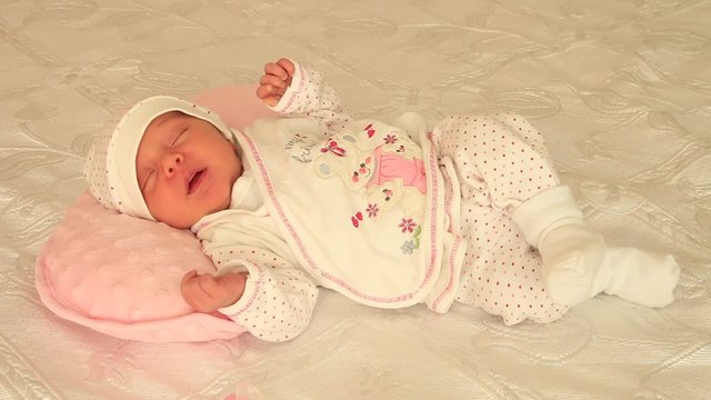 bebek yatağın &uuml;zerinde uyuyor