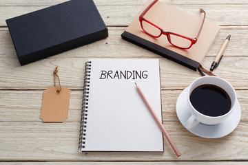 Branding concept with notebook, brand tag, product box , glasses and coffee cup on work desk