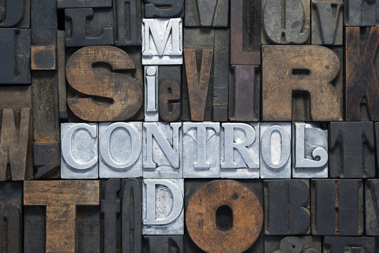mind control cross words made from metallic letterpress blocks in mixed wooden letters 