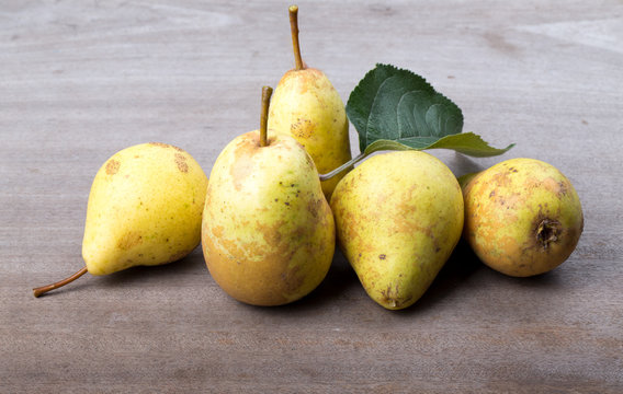 Yellow seasonal pears with leaf on the background of old boards.