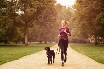 Gesunde Frau joggt mit ihrem Hund