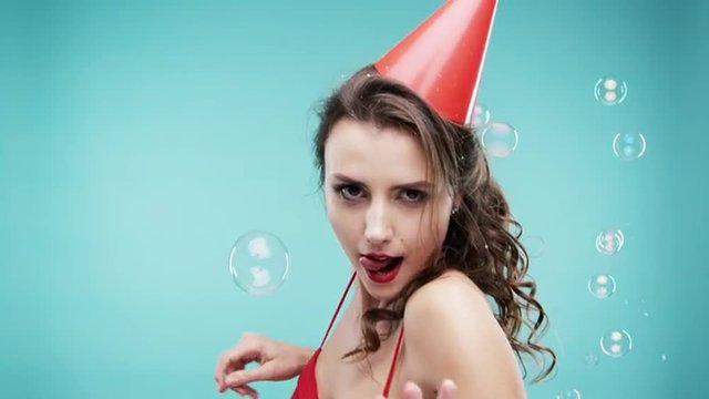 Crazy face sexy woman dancing in bubble shower slow motion photo booth blue background