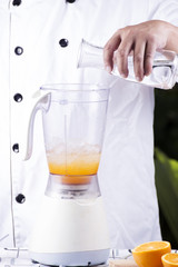 Chef pouring water in to electric Blender